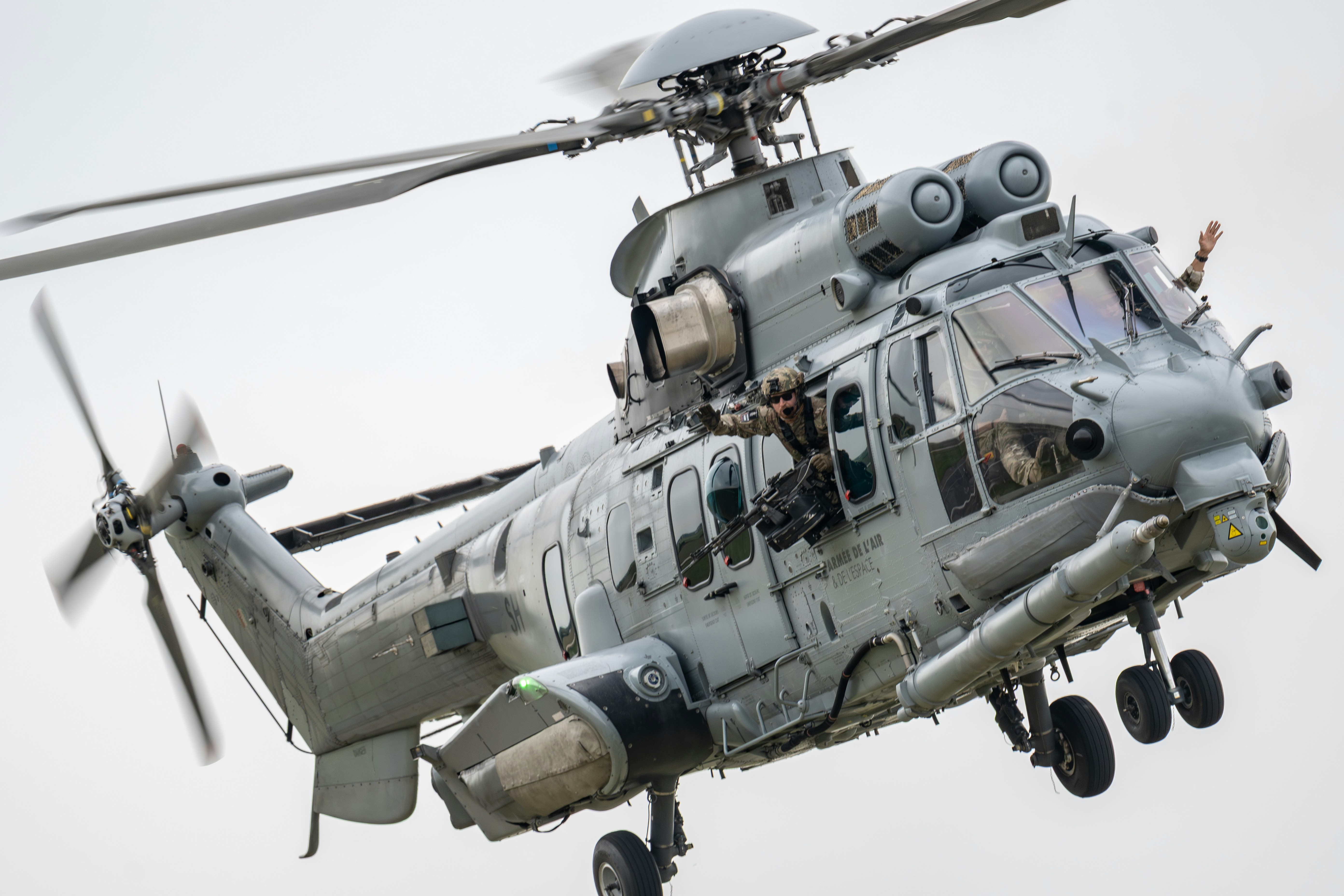 Un hélicoptère militaire vole dans les airs.