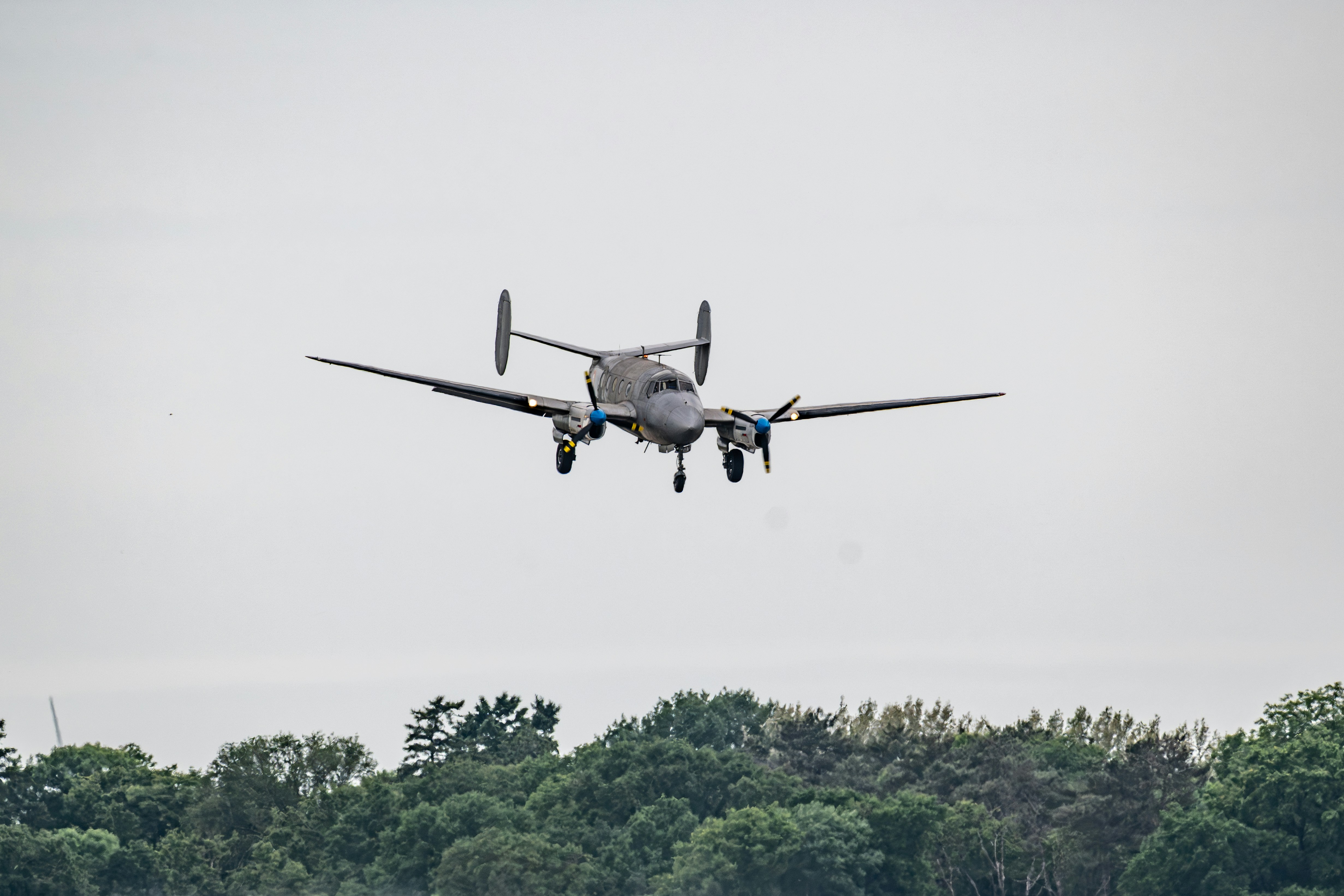 L’avion vole dans le ciel au-dessus des arbres.