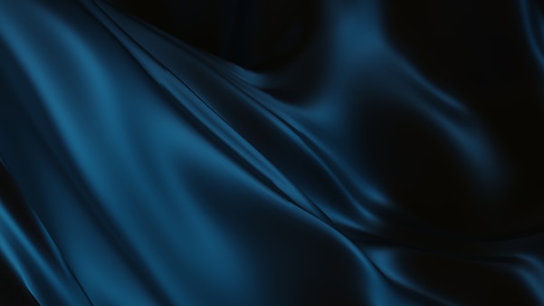 Flowing blue fabric against a dark background.