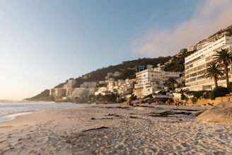 Beachfront buildings line the coast at sunset.