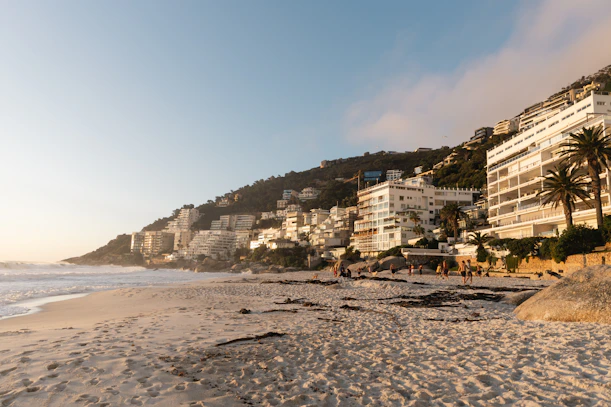 Beachfront buildings line the coast at sunset.