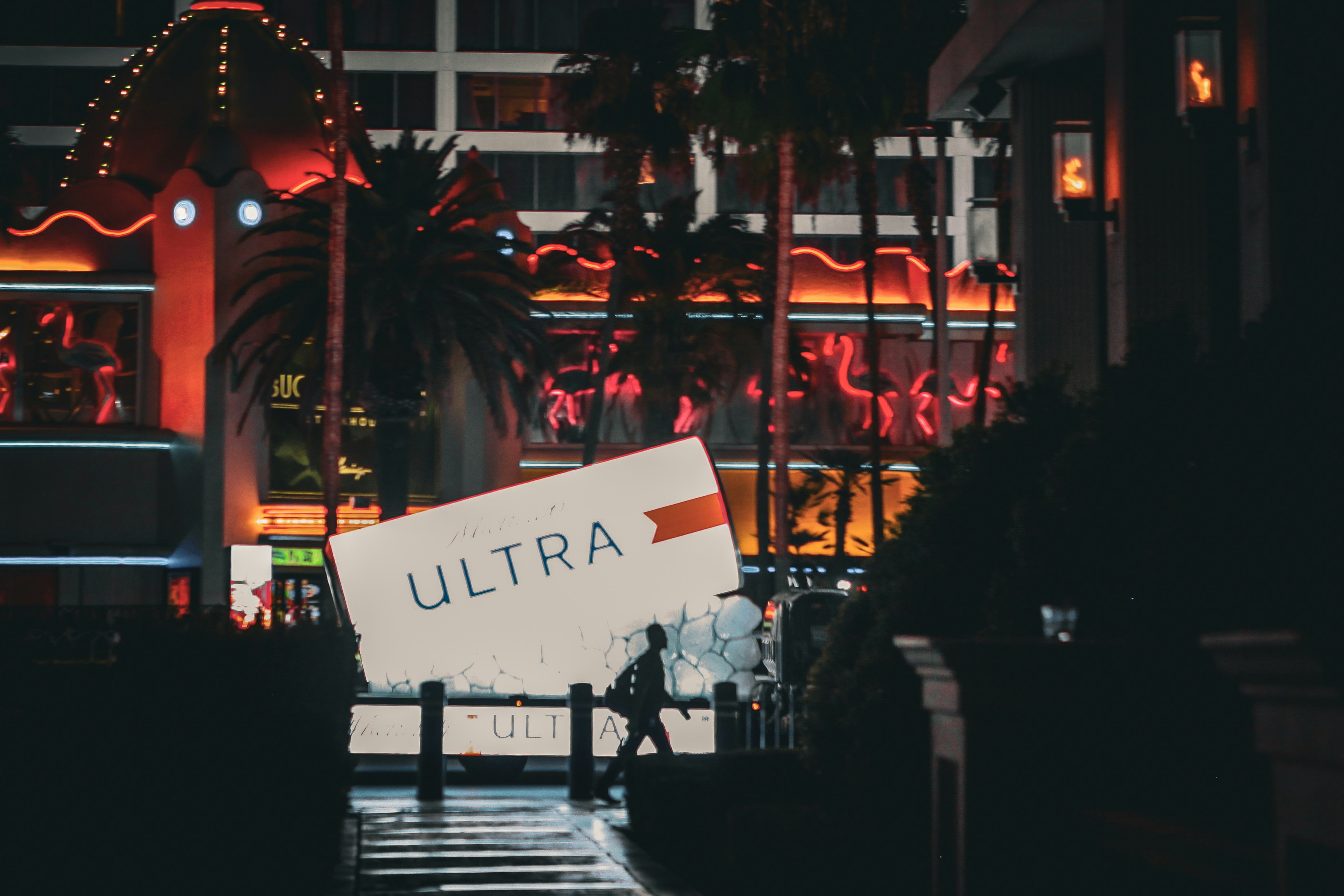 A person walks in front of a sign.