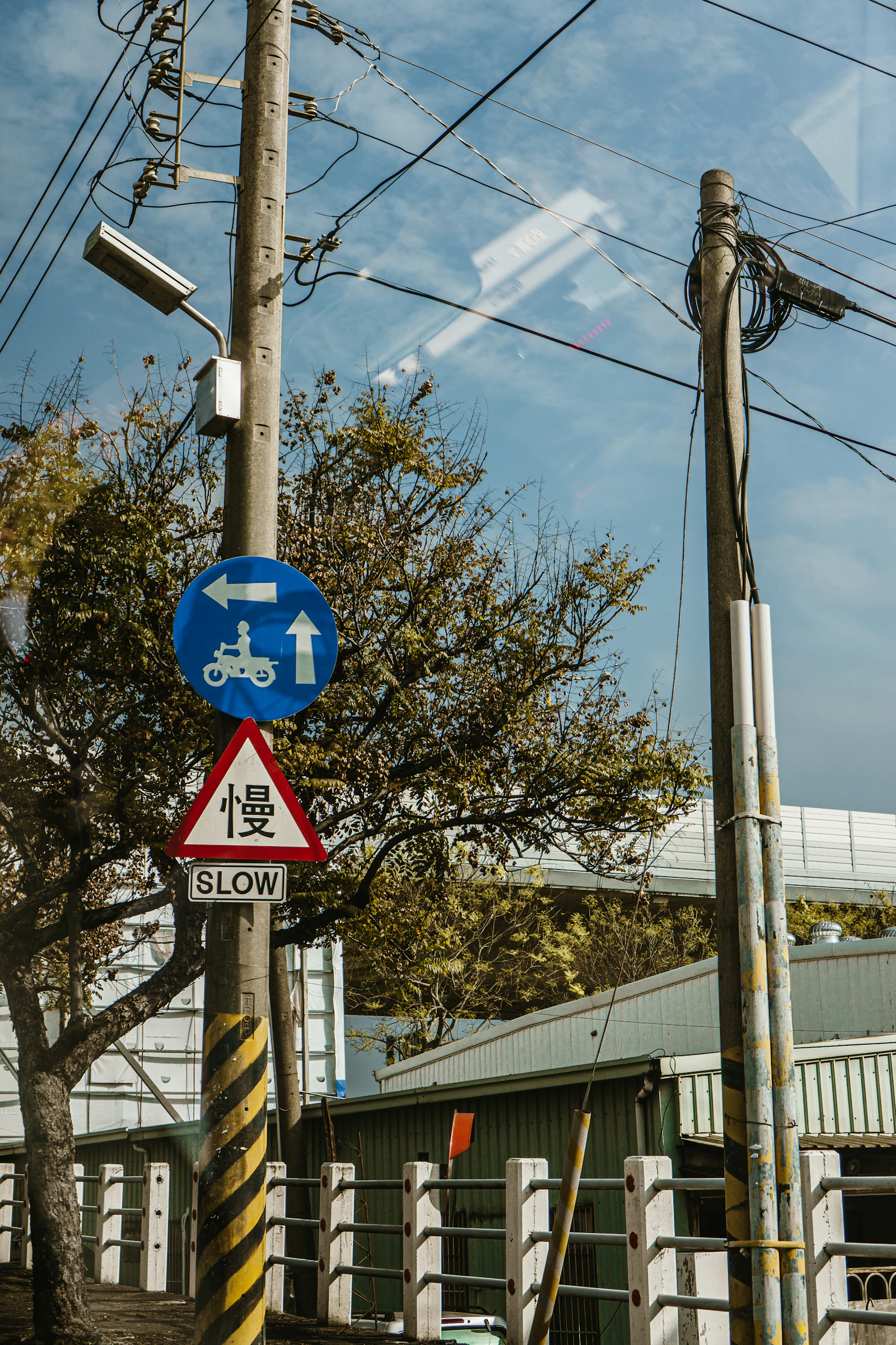 A slow sign and separate scooter direction on a Taiwanese street