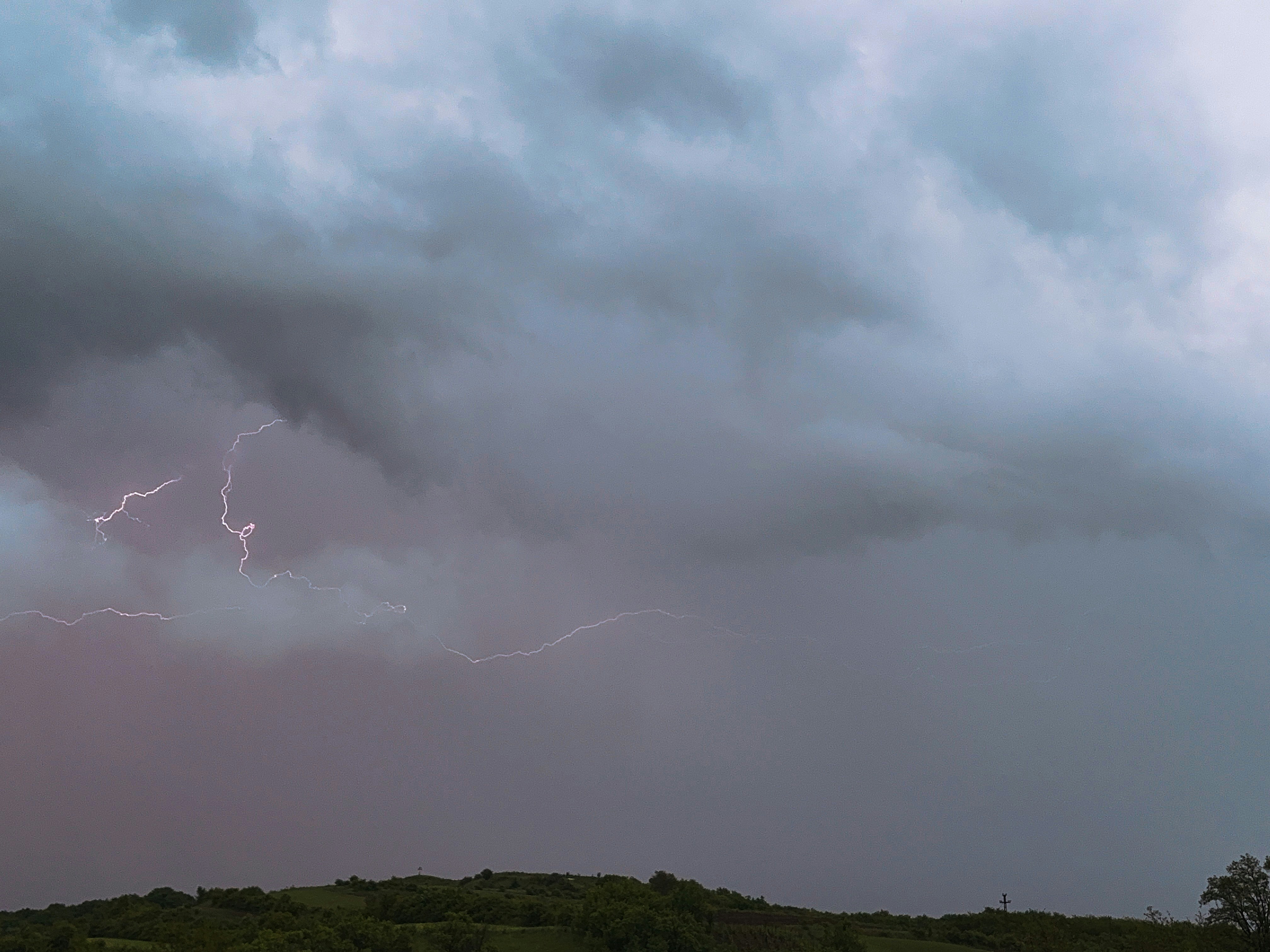 Lightning strikes during a stormy, cloudy evening.