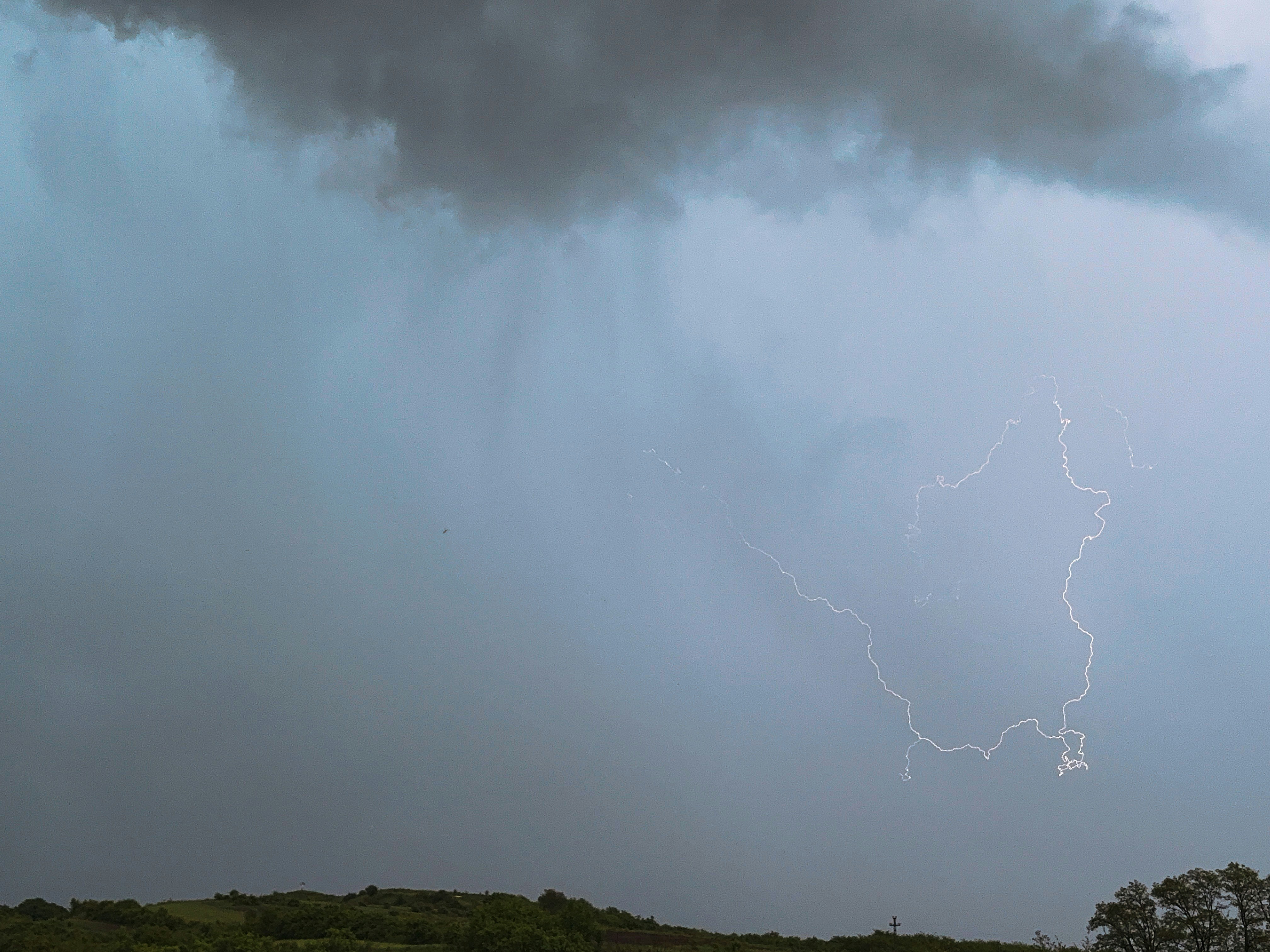 Lightning streaks across a cloudy, stormy sky.