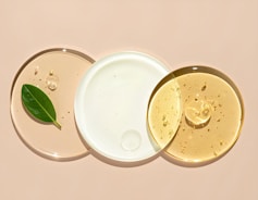 Cosmetic serums arranged on clear, circular plates.