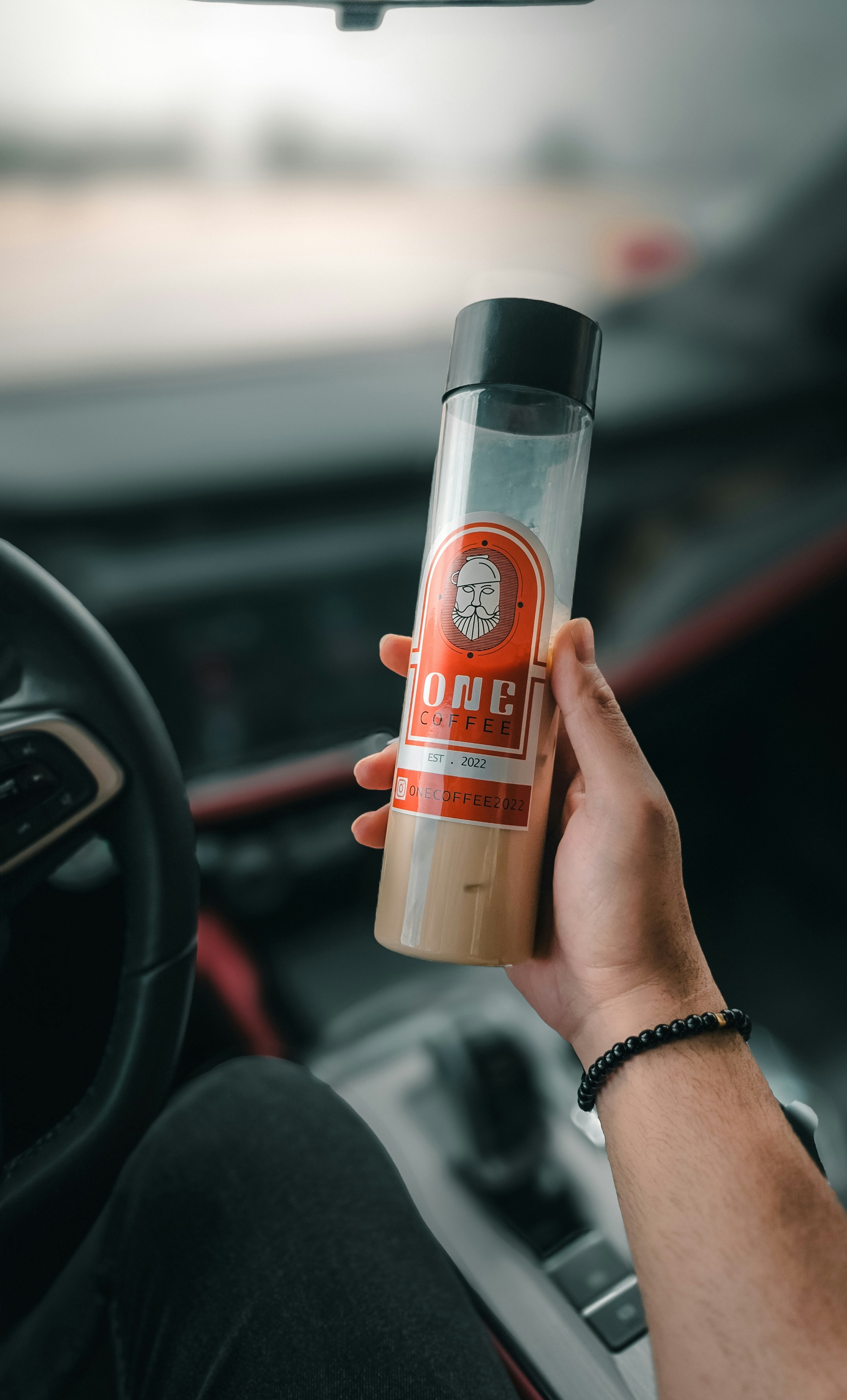 Una persona tiene una bottiglia in un'auto.