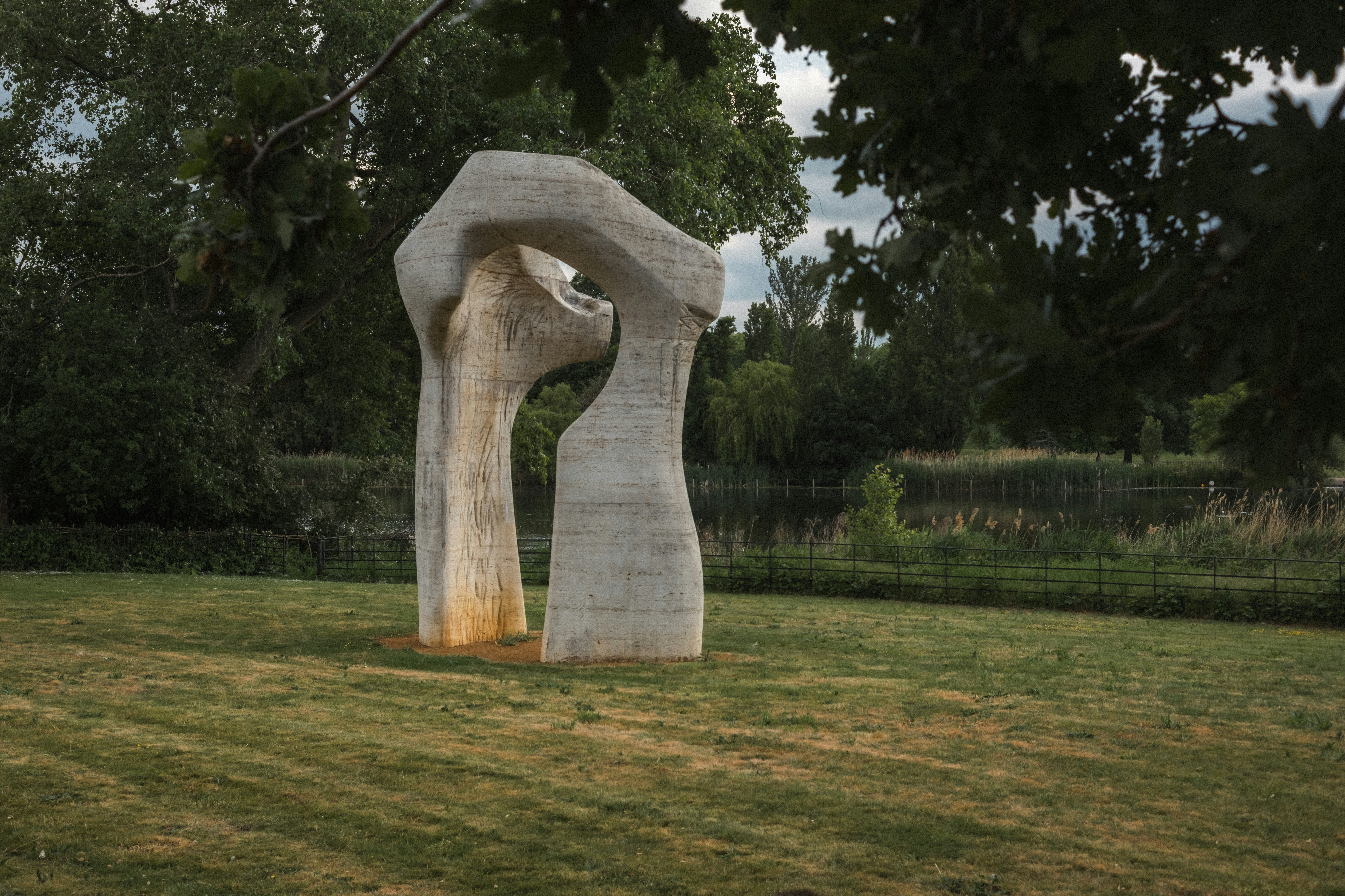 Sculpture stands on green grass in a park.