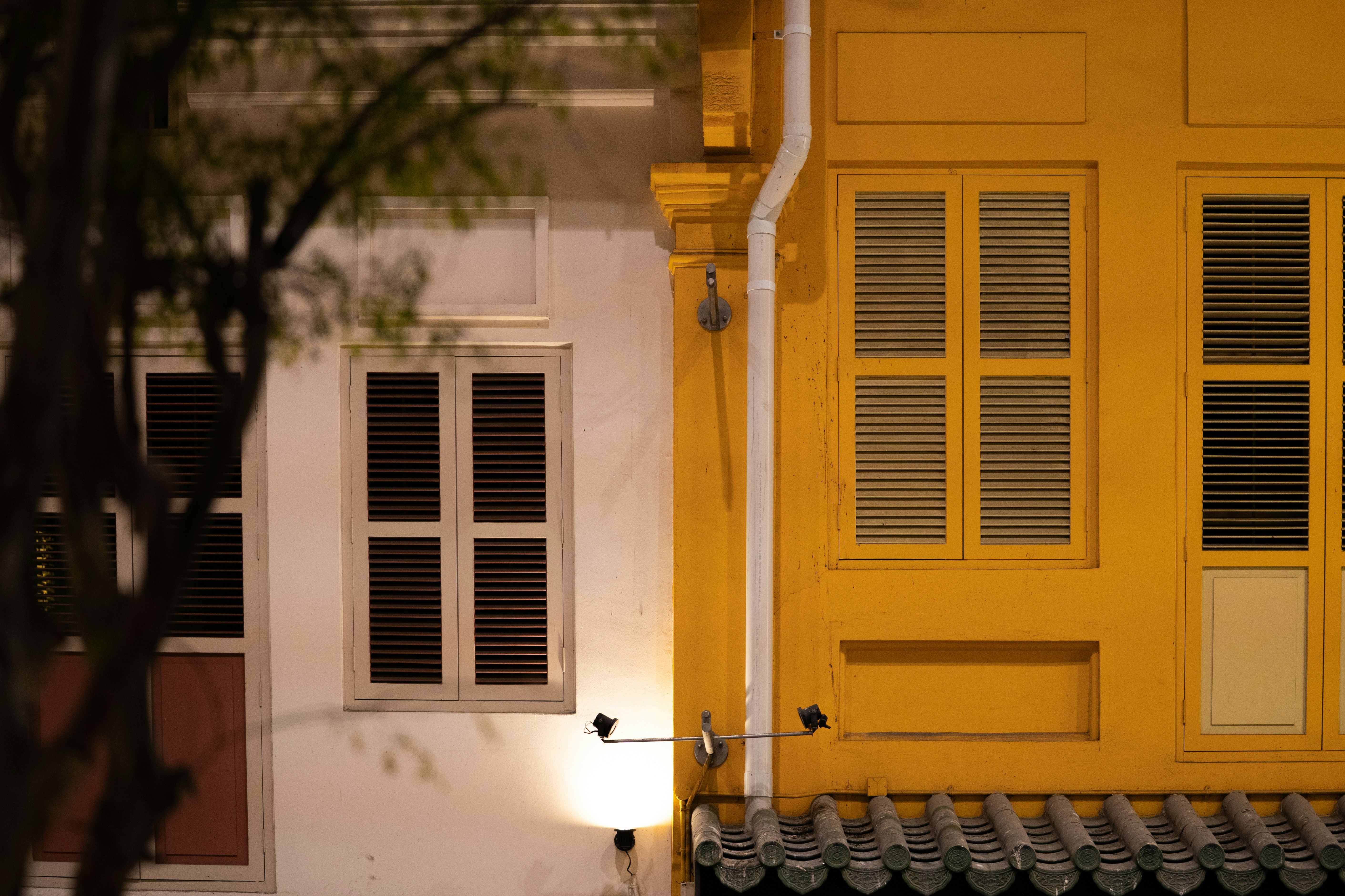 Buildings with shuttered windows illuminated at night.