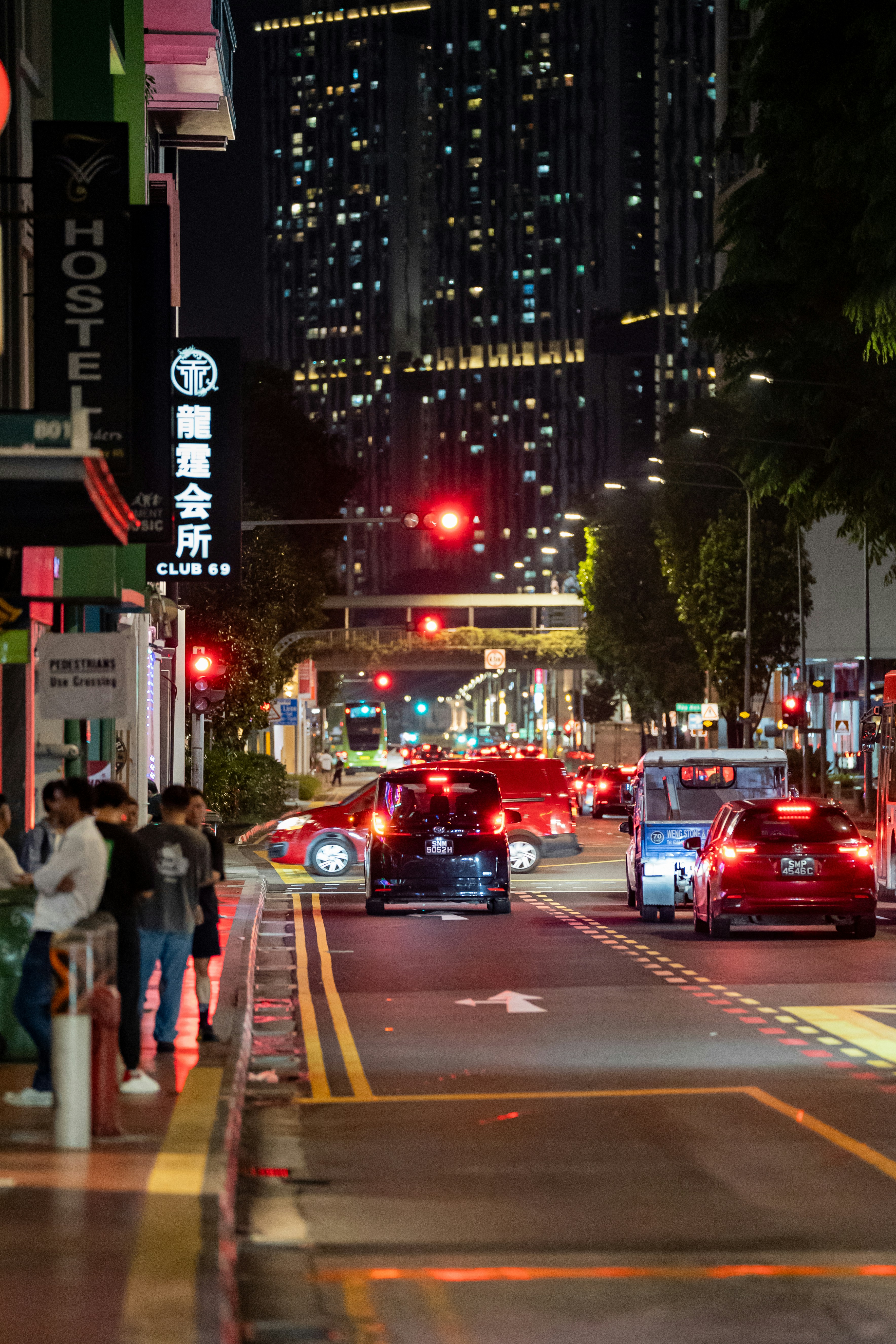 City street at night with lights and traffic.
