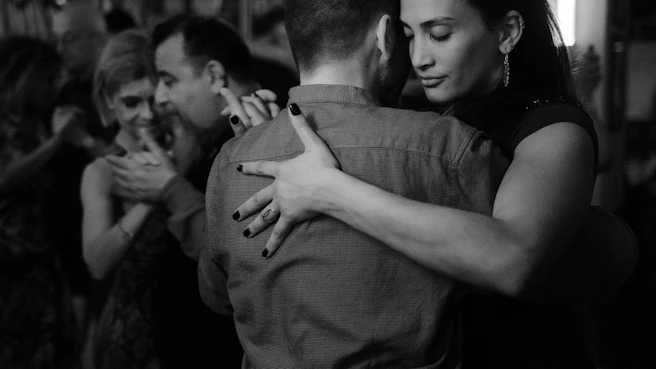 People are dancing closely together in a ballroom