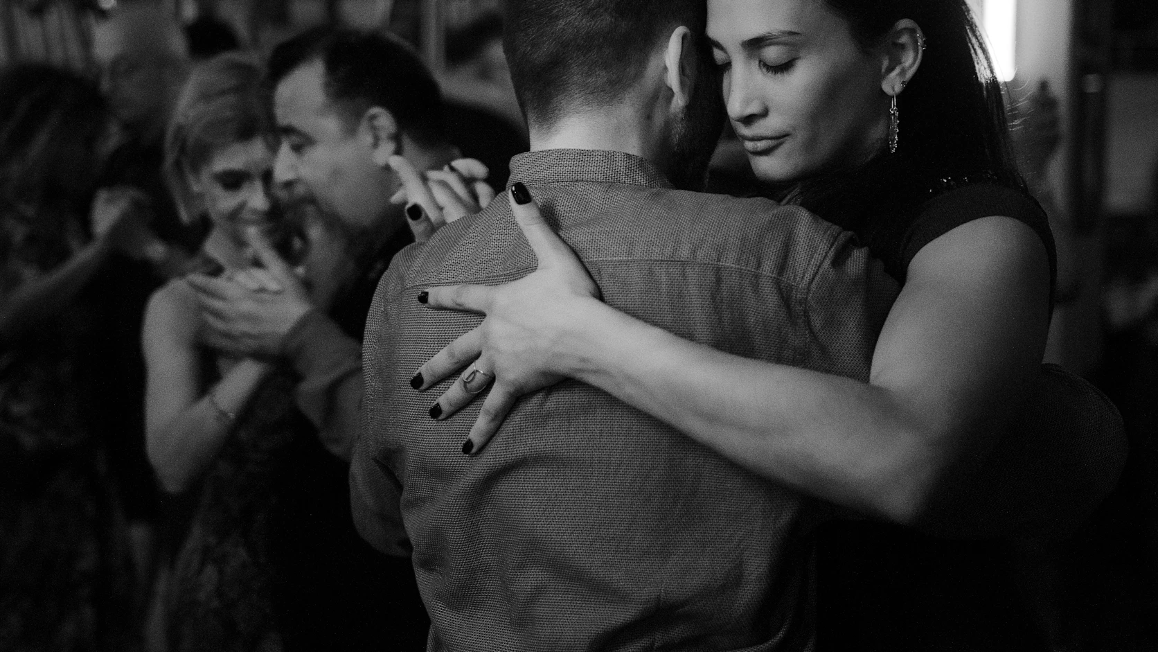 People are dancing closely together in a ballroom