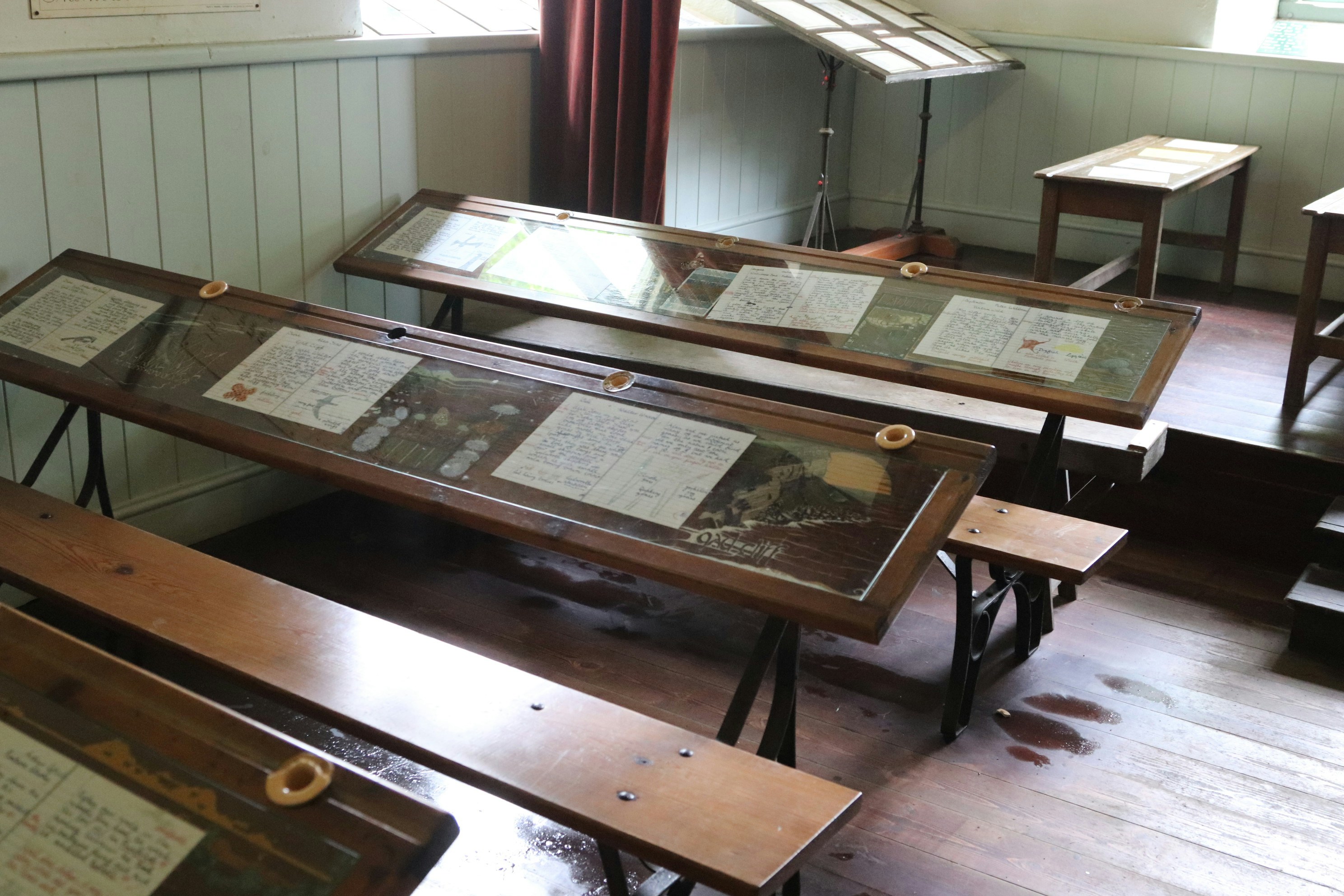 Old school desks sit in a classroom.