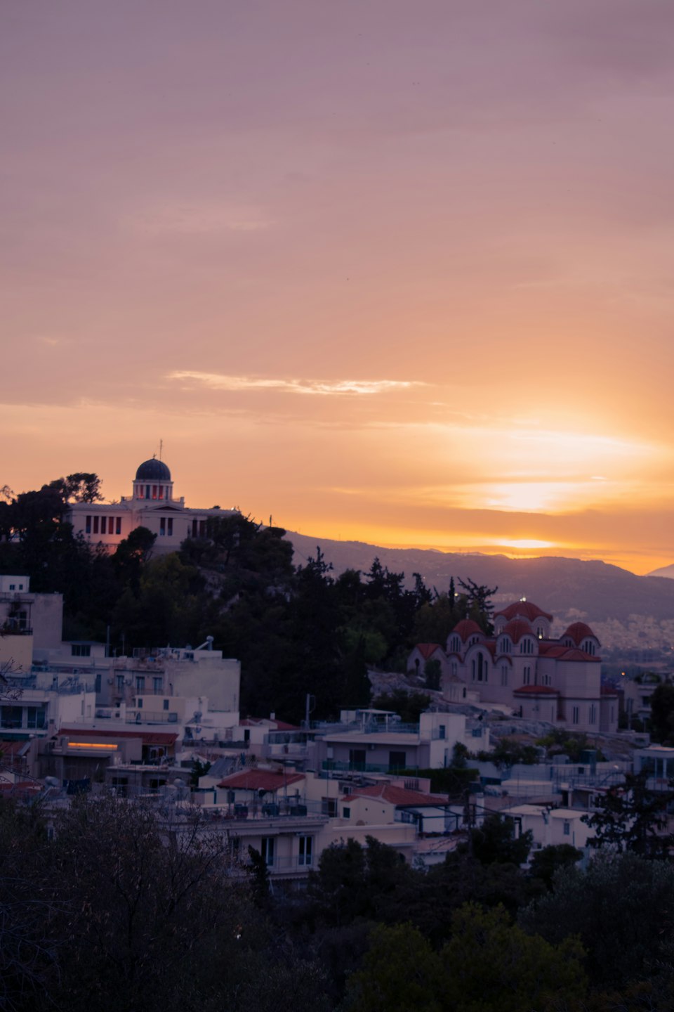 Athens rooftops and skyline bathed in warm sunset light