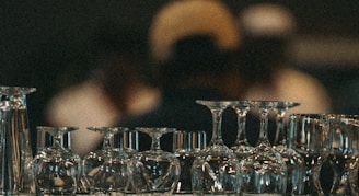 Wine glasses are stacked upside down on a shelf.