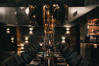 A dark, elegant dining room with long table.