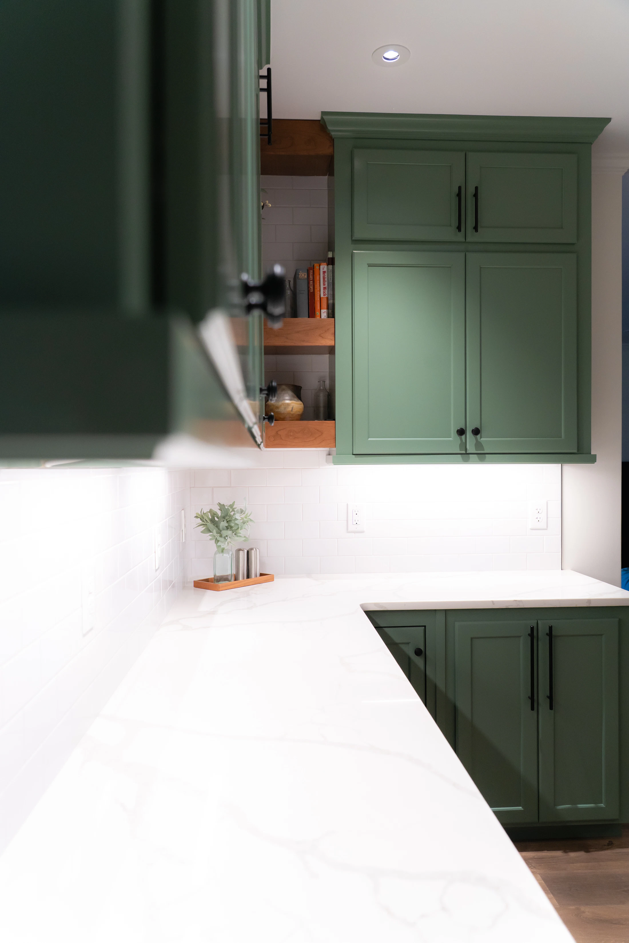 Completed kitchen cabinetry in a deep green painted finish