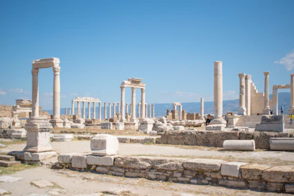 Ancient ruins stand against a bright blue sky.