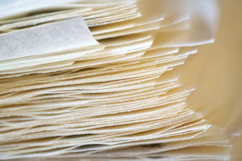 Here is a caption for the image: a stack of thin, layered paper.