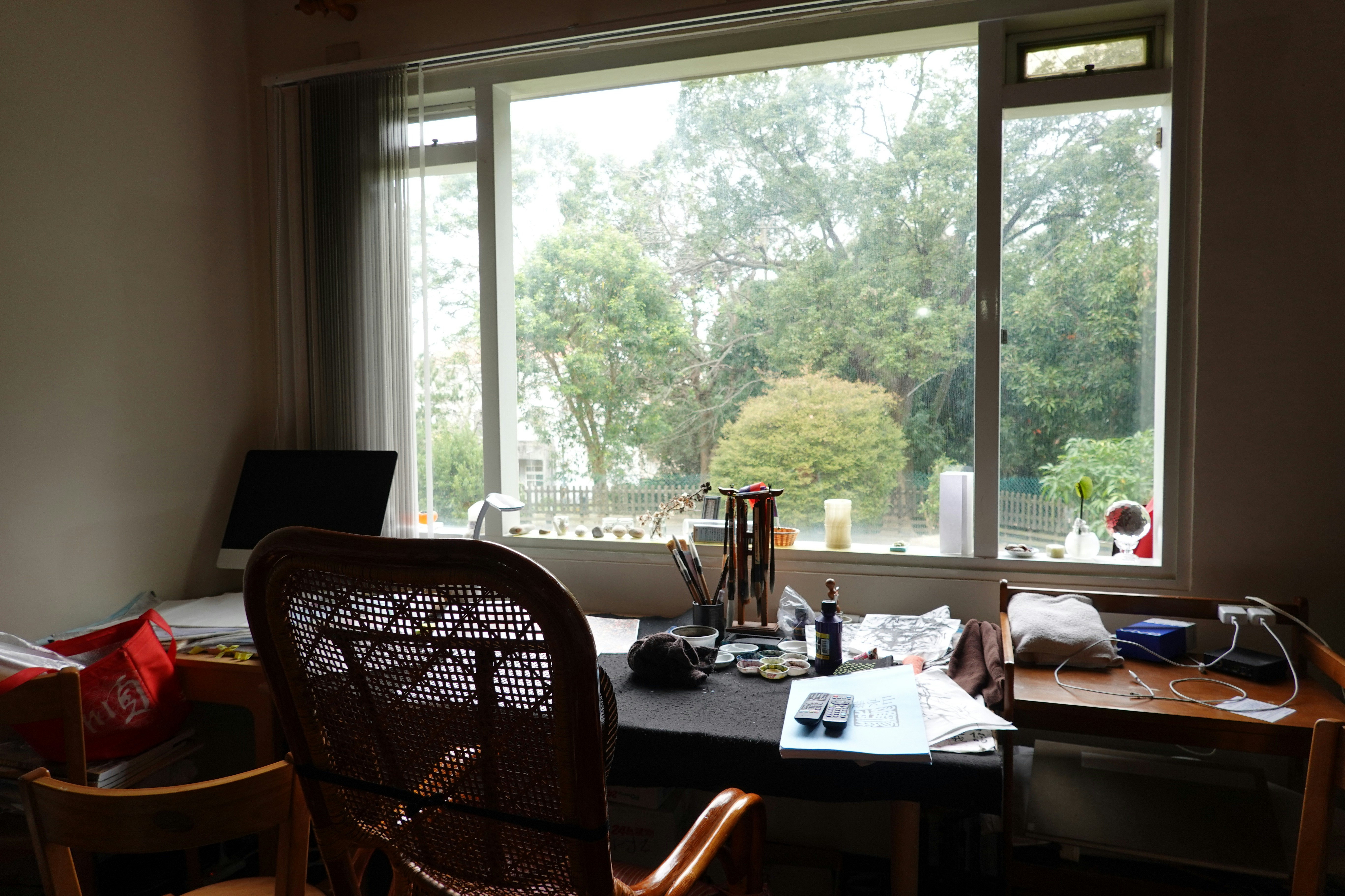 A desk sits near a large window