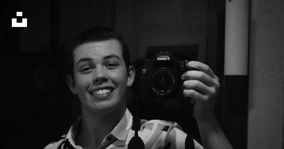 Ppc Arows Code Man smiles while taking a selfie with a camera. photo – Free Portrait ...
