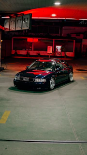A dark audi sits at a gas station.
