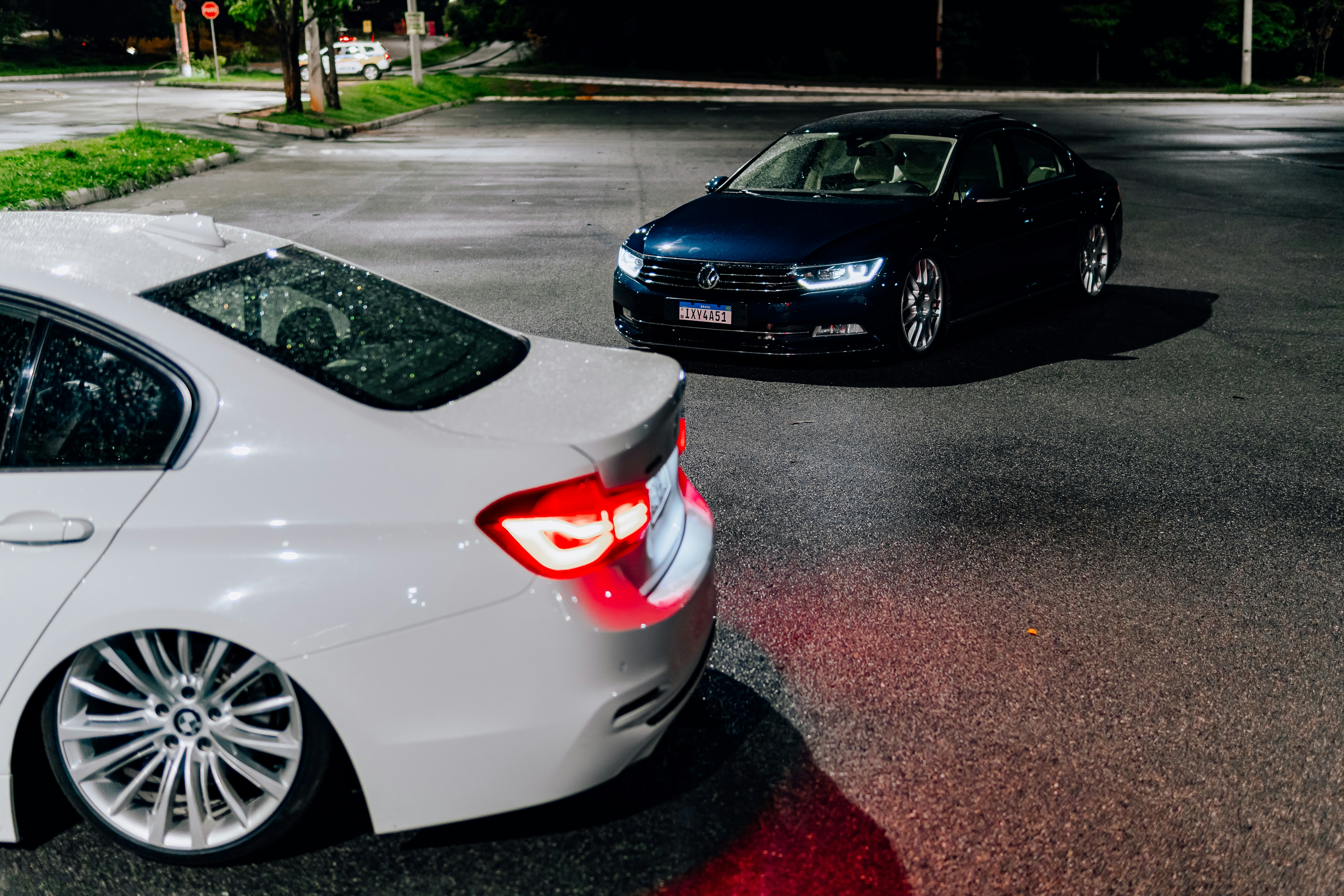 Two cars parked on a dark street.