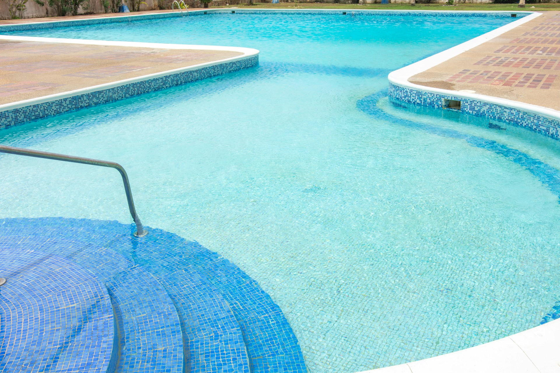 A bright blue swimming pool with steps.