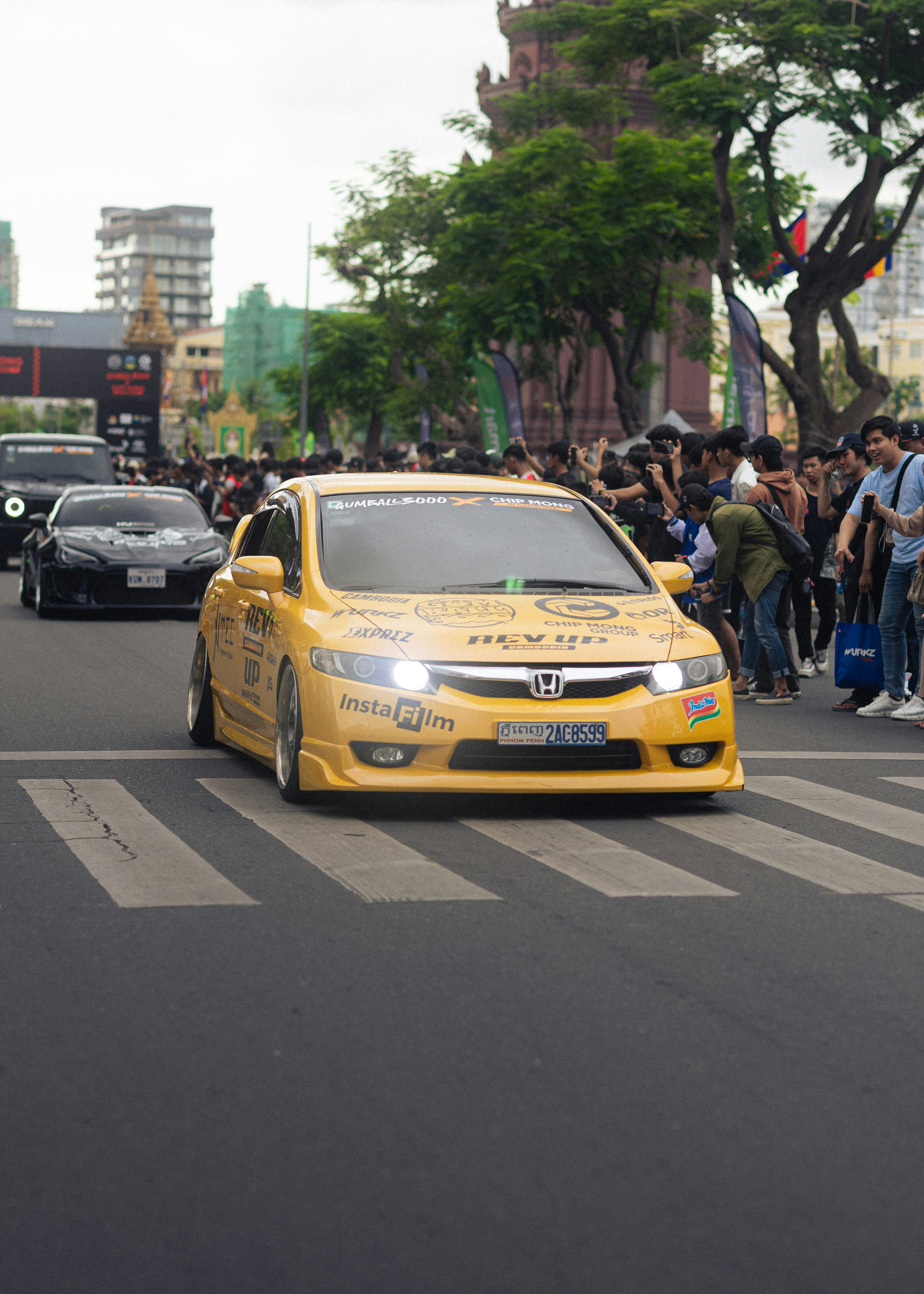 A yellow car is crossing a crosswalk.