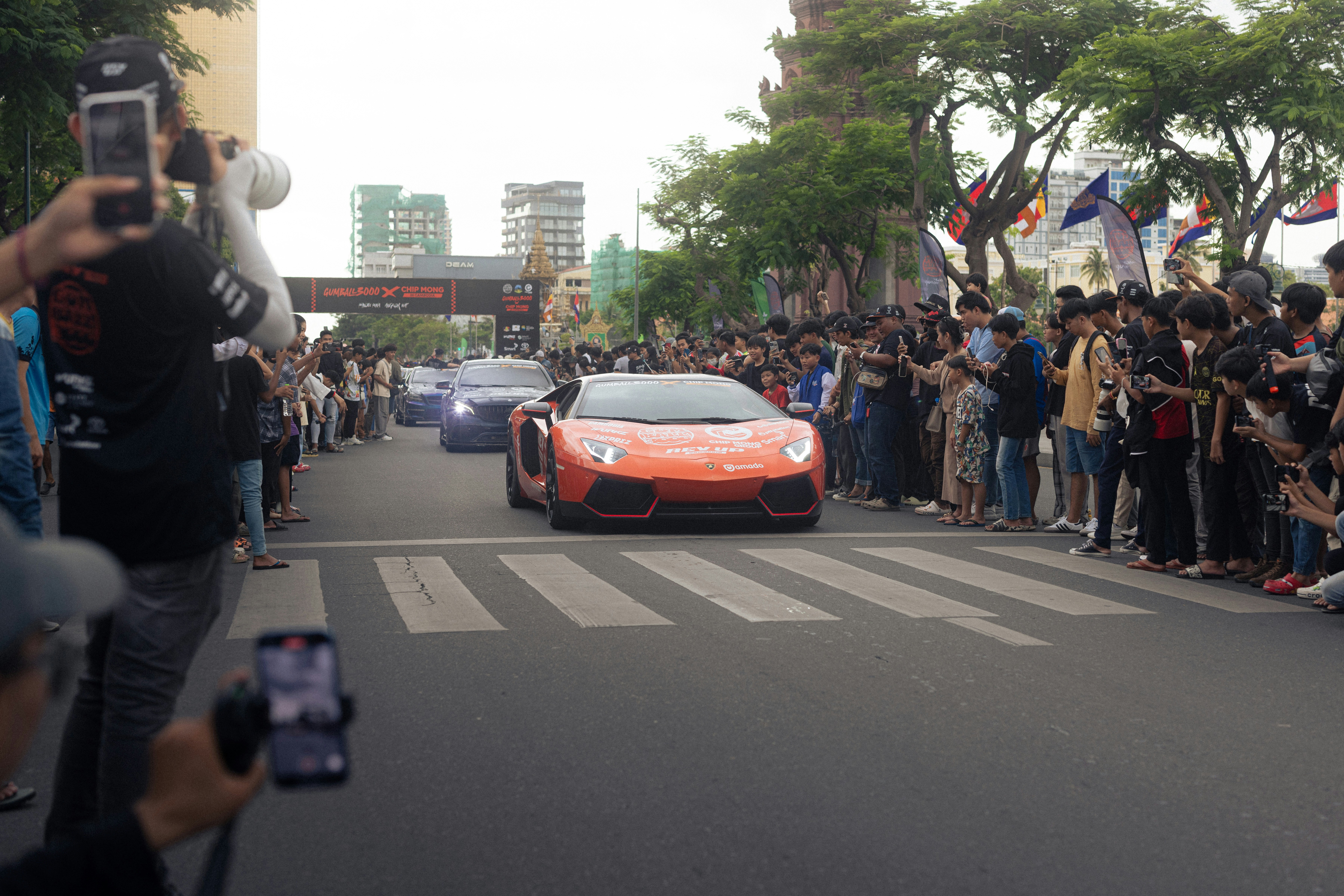 People watch cars parade down a street. photo – Free Bmw Image on Unsplash