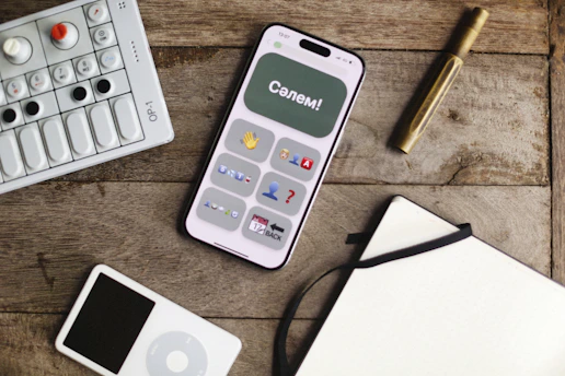 Phone, music player, and more on a wooden table.