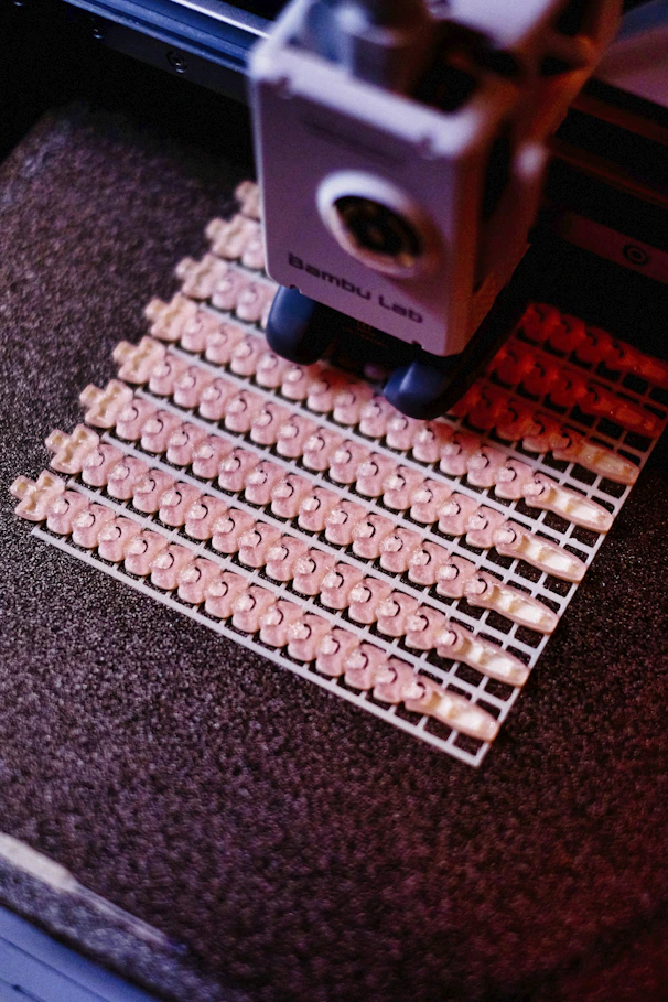 A machine is cutting rows of small plastic parts.