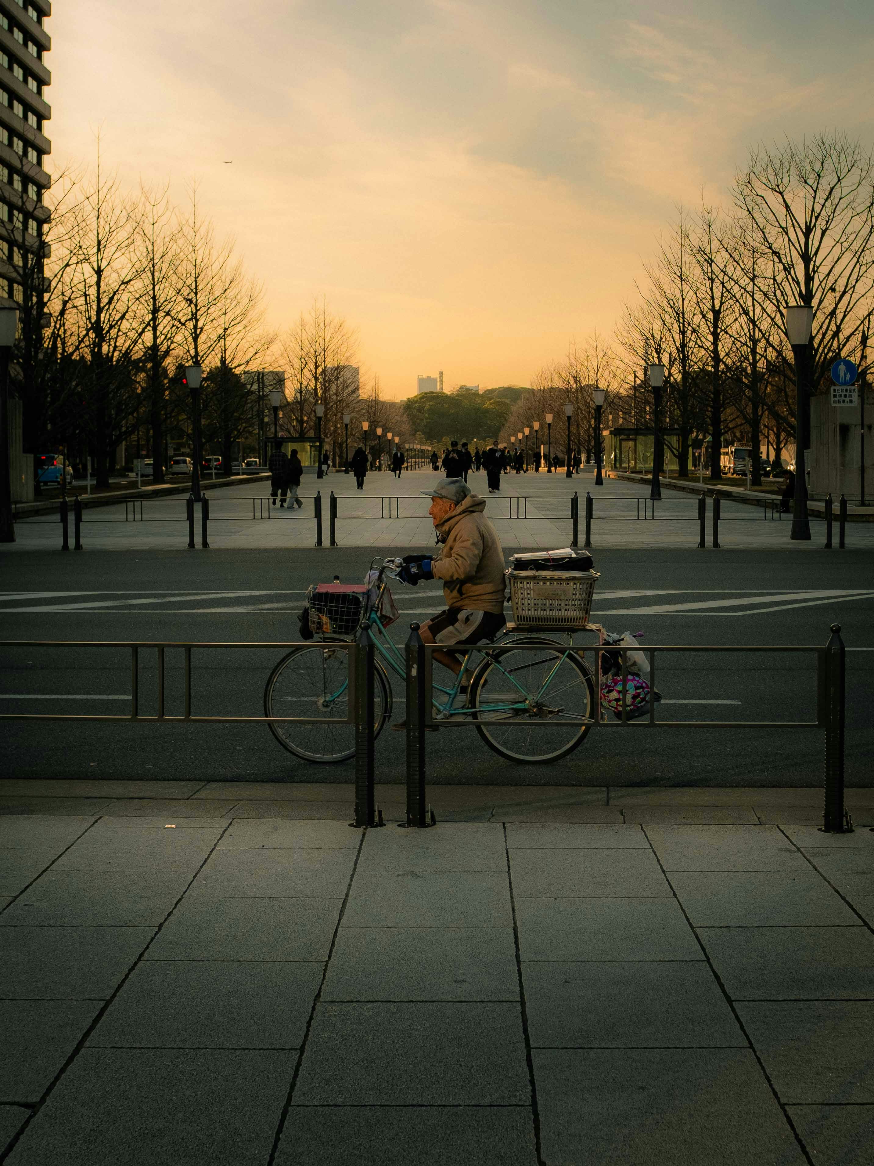 A person on a bicycle rides down the street.