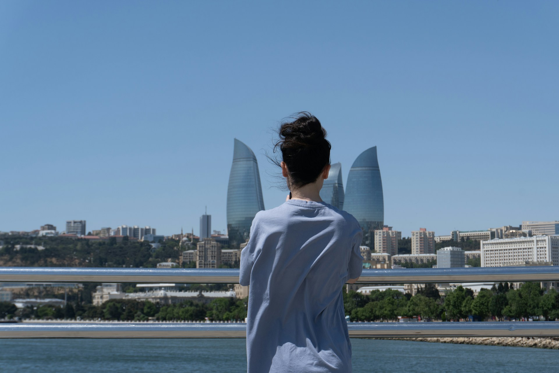 A woman appreciates a city view under the sun.