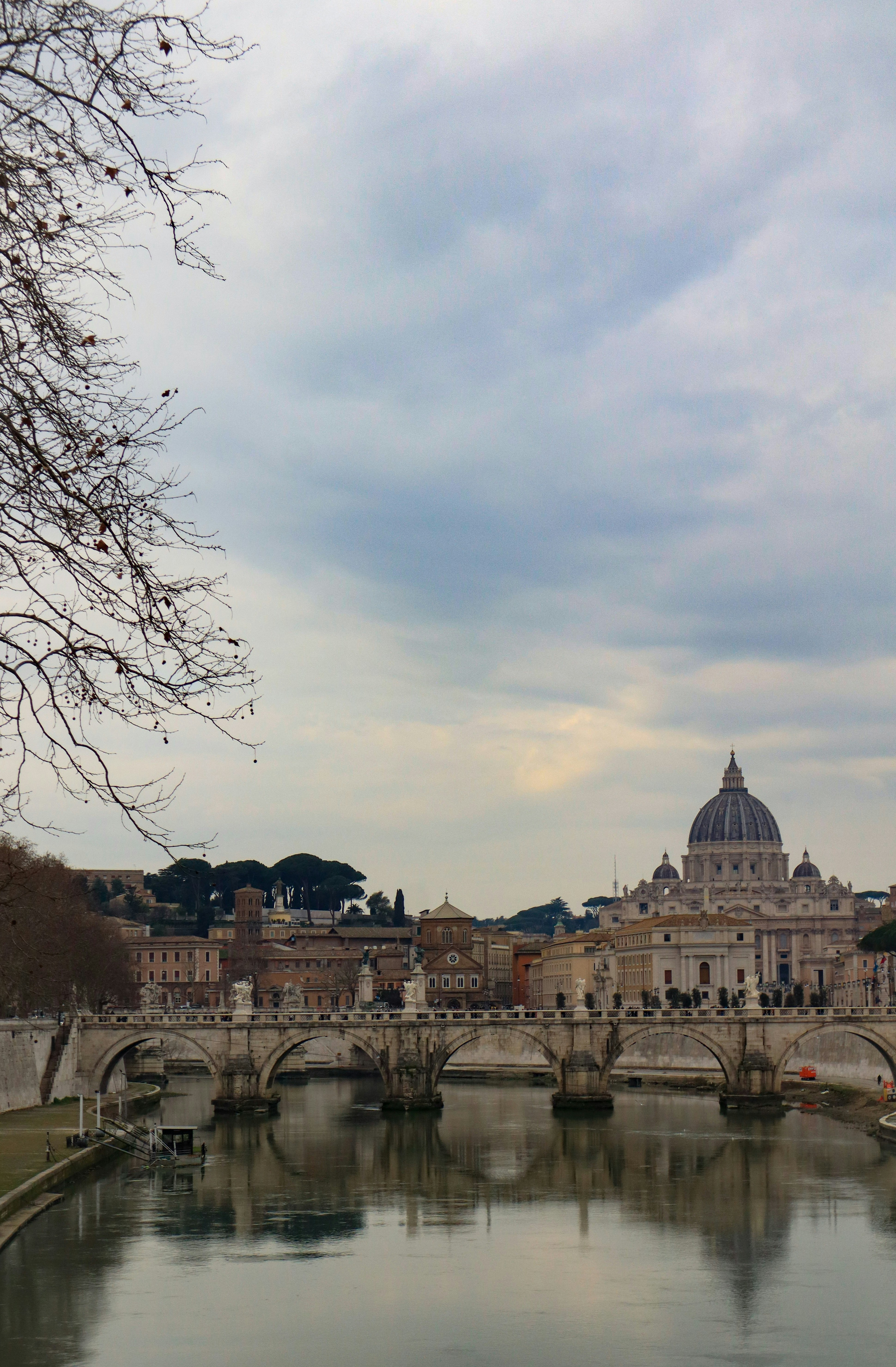 A bridge over a river, leading to st. peter's basilica.