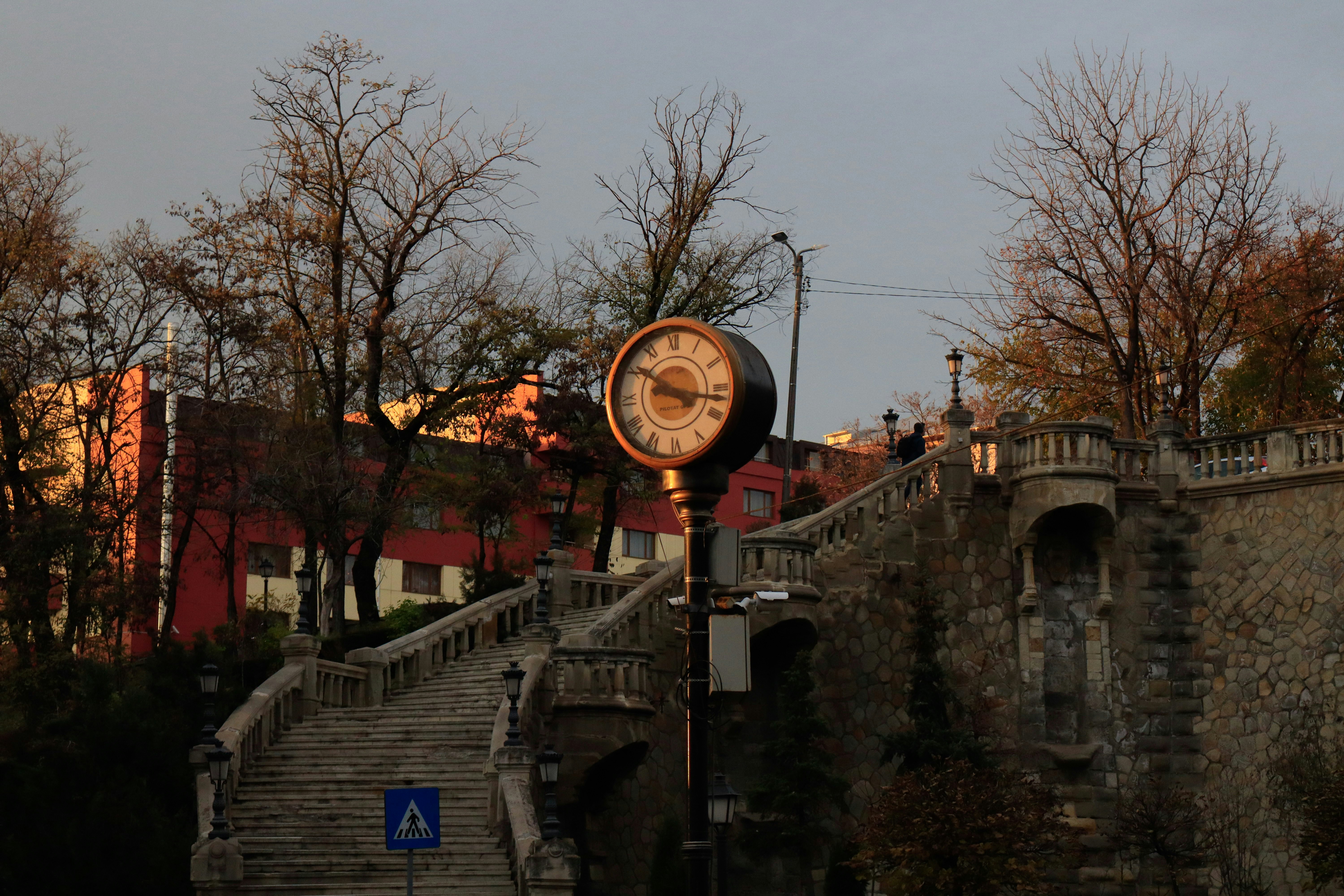 A clock and a staircase in a city landscape.