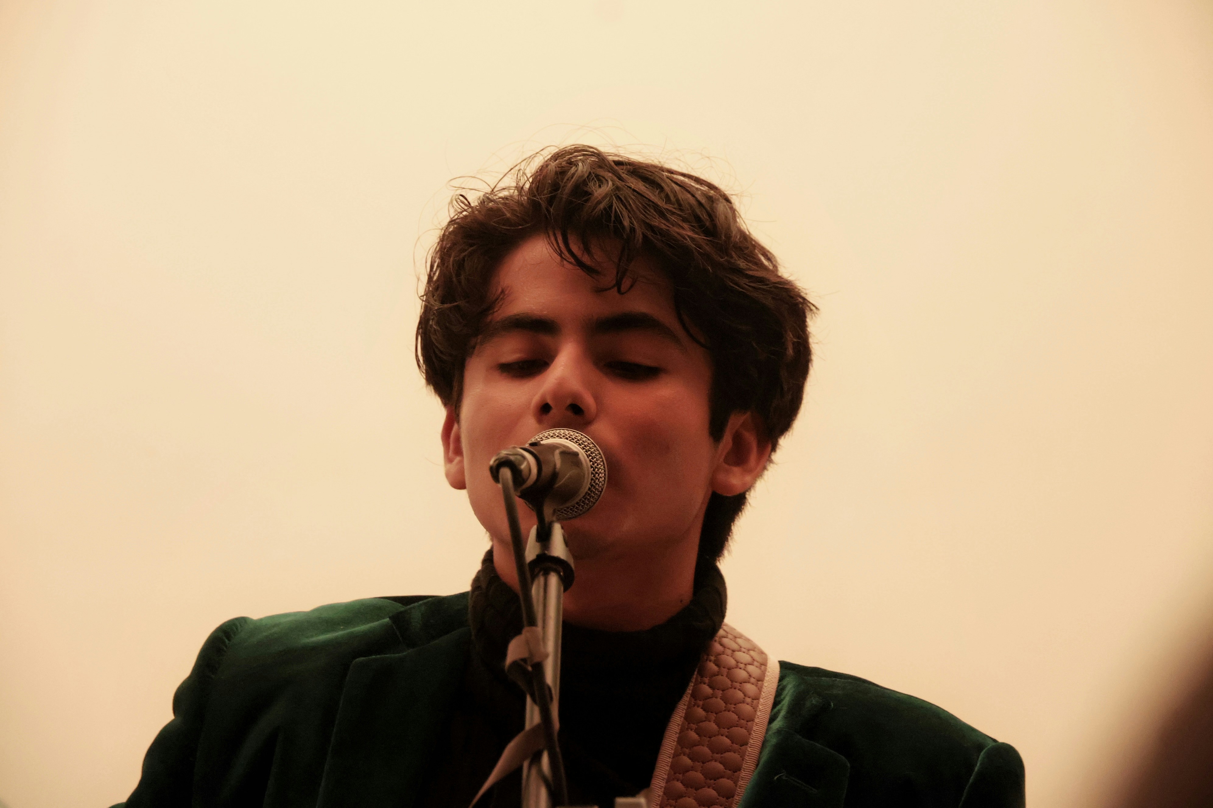 A young man sings into a microphone