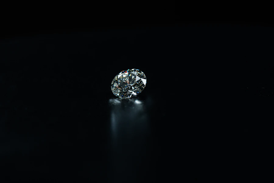 A single round brilliant diamond catching the light on a black background