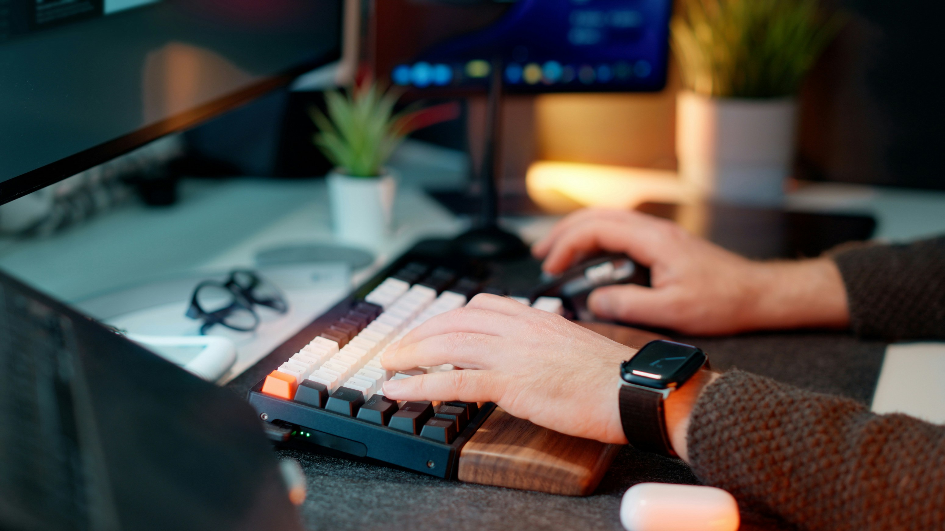 software engineer typing on split mechanical keyboard in modern office