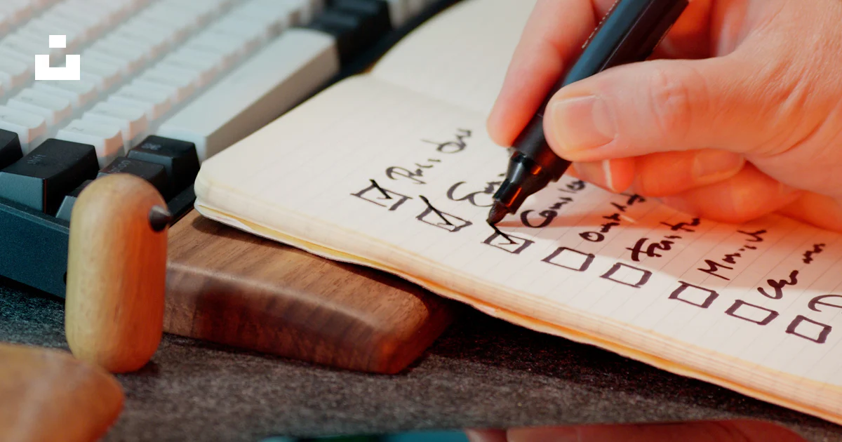 Someone is writing in a notebook with checkboxes. photo – Free Office ...
