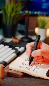 A hand is writing on a notepad.