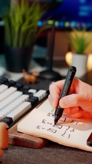 A hand is writing on a notepad.