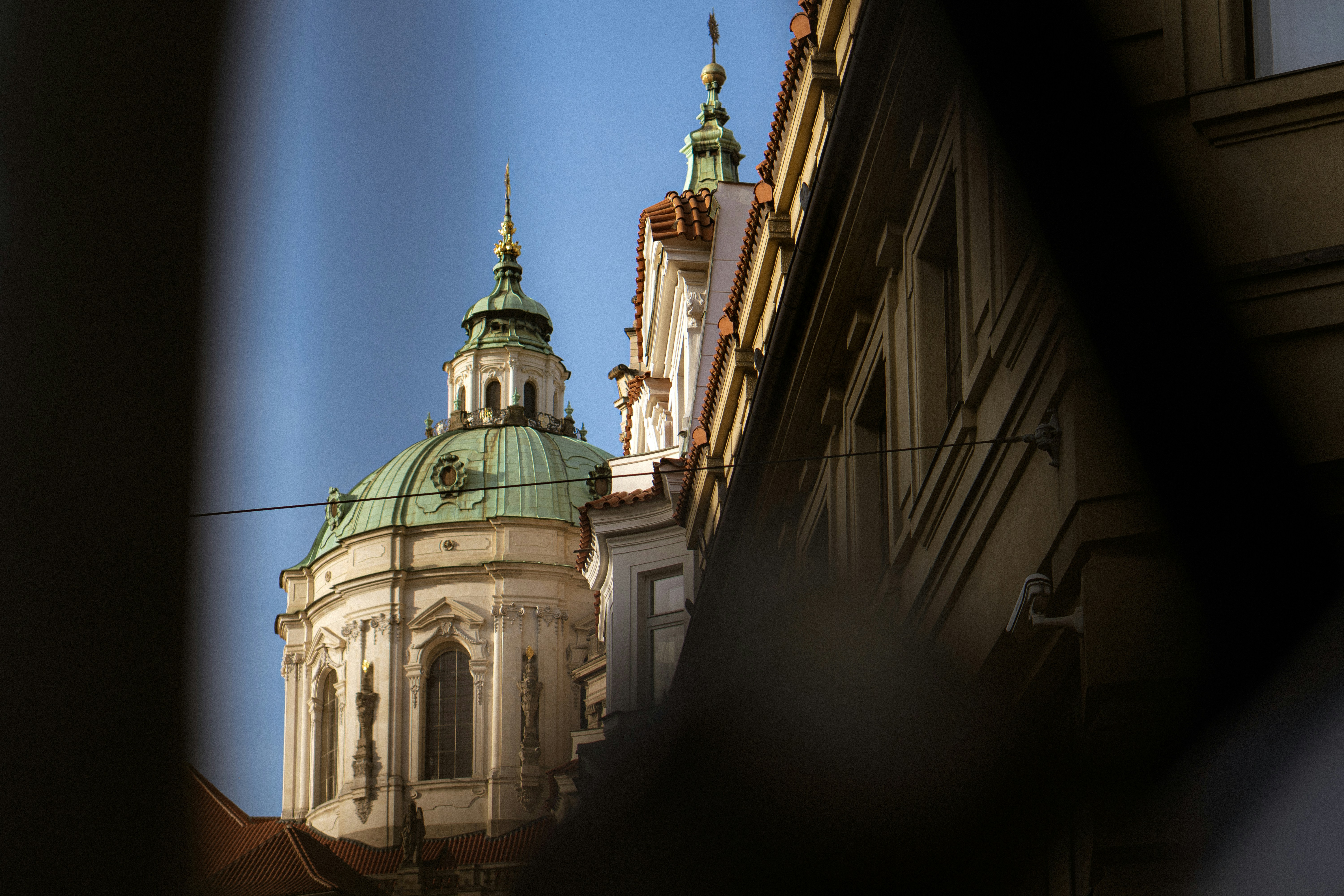 Buildings and a domed church are seen through a frame.