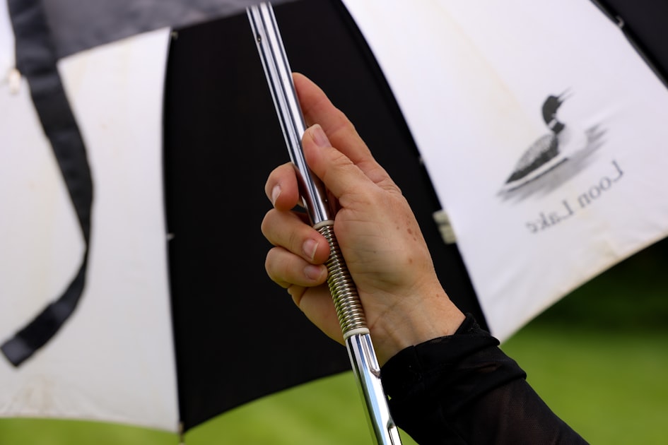 A hand holds open a black and white umbrella.