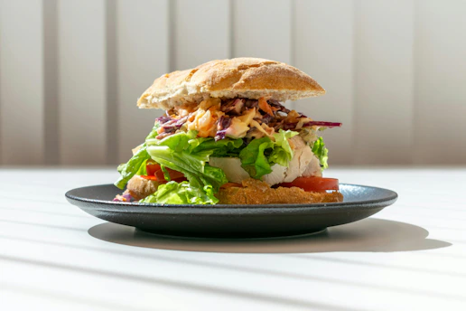 A delicious burger on a dark plate.