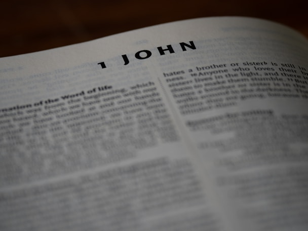A bible is open to the book of 1 john.