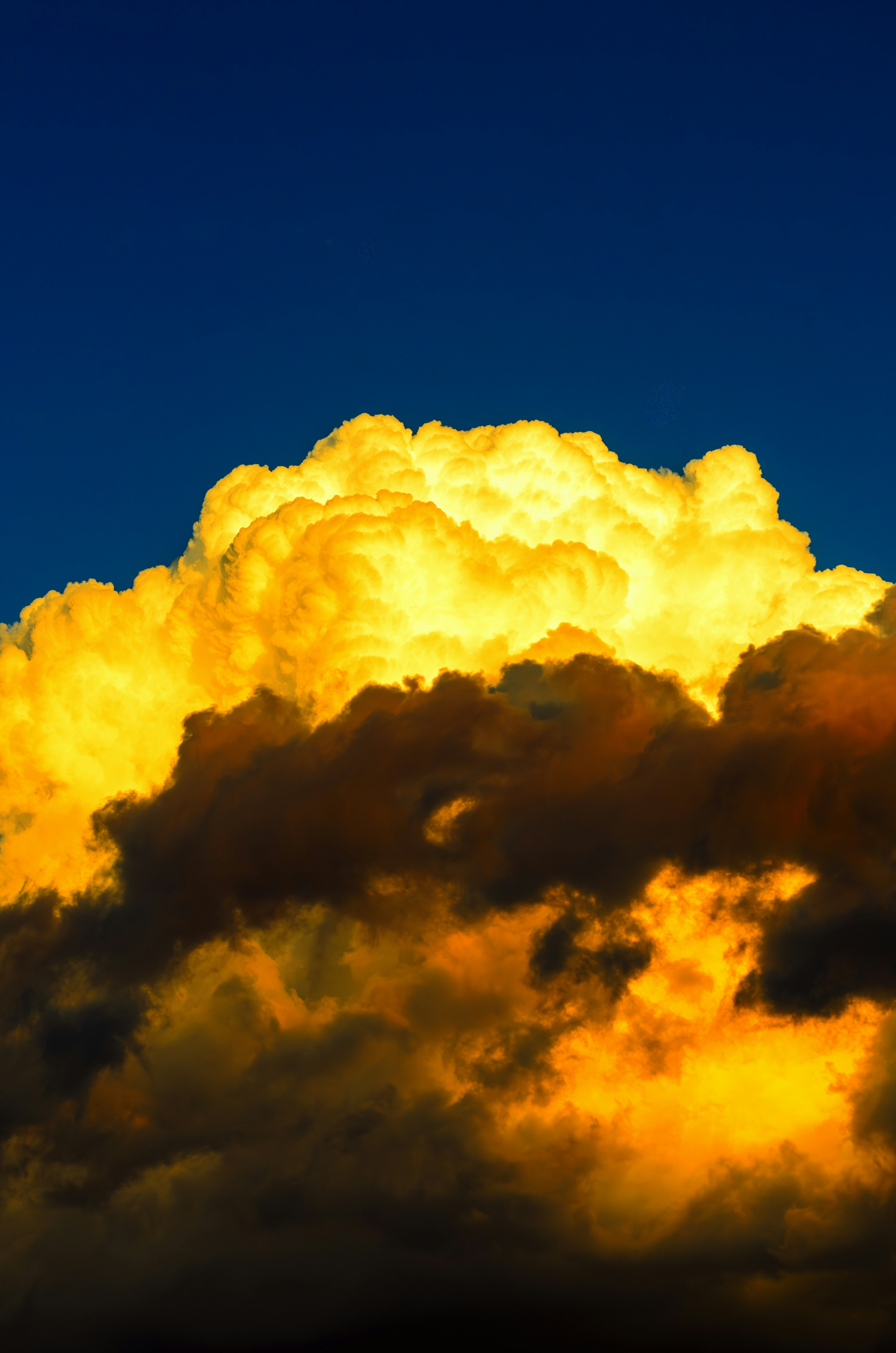Golden clouds glow against a dark blue sky.