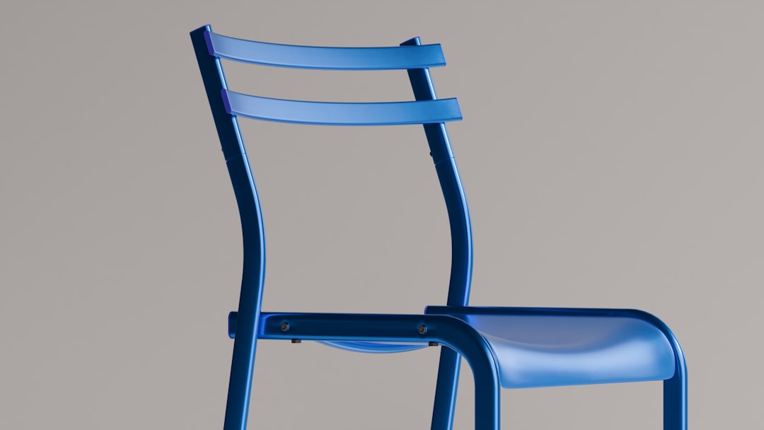 A sleek, blue chair stands out., The Geneson Chair is a contemporary design statement — a symphony of smooth curves and bold geometry. Balancing form and function, it stands as an emblem of innovative seating.