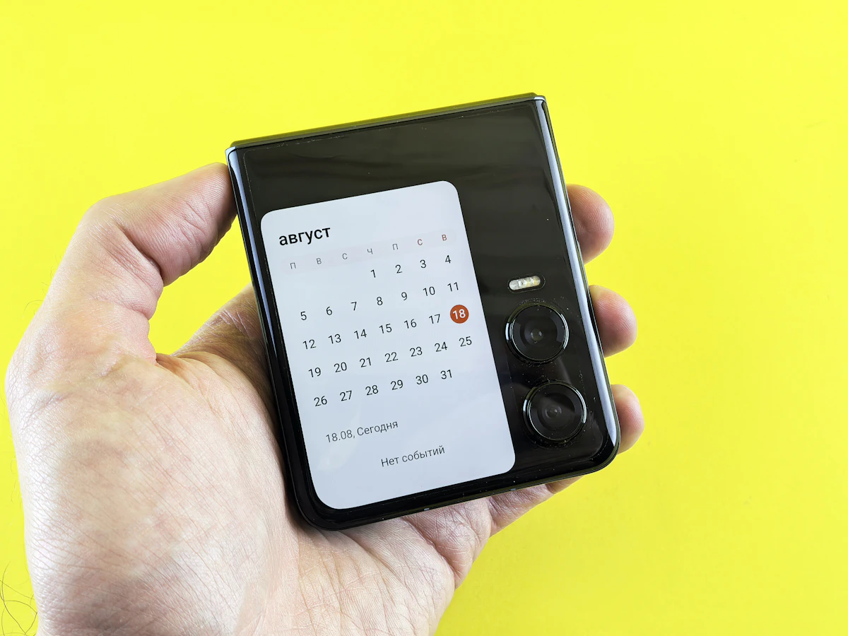 手に持ったスマートフォンにカレンダーを表示したイメージ写真