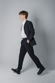 A man walks confidently in a suit.